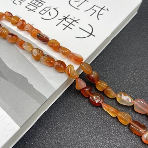 Close-up of irregular natural red agate stone beads showing translucency and texture