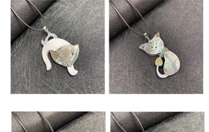 Dettaglio di ciondoli a gatto in madreperla e abalone su collane in cordino nero