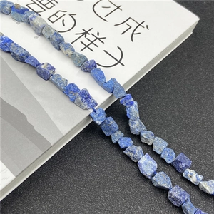 Macro shot of irregular deep blue natural lapis lazuli raw stones on a blue string