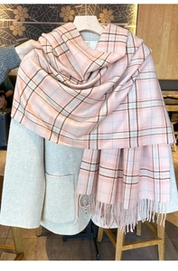 Detailed view of the soft pink checkered scarf texture with elegant fringe tassels
