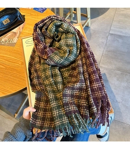 Close-up of thick checkered scarf with green and purple tones and fringe edges