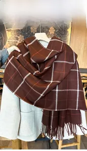 Détail d'une écharpe d'hiver à carreaux marron et blanc avec de franges épaisses