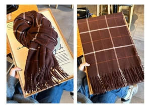 Vue détaillée d'une écharpe à carreaux marron avec maille épaisse et longs franges