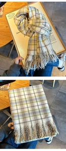 Detail shot of checkered tassel scarf with soft plaid pattern and warm fringe textures