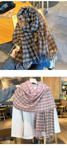 Close-up of thick checkered scarves with handmade tassels in blue-brown and pink-white colors