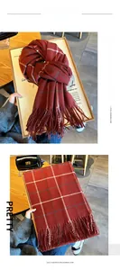 Détail d'une écharpe à carreaux rouges et pompons en imitation cachemire doux au style rétro