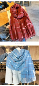 Détail de la texture de l'écharpe à carreaux rouge et bleu avec franges