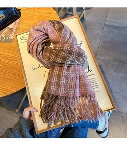 Detail of checkered winter scarf with thick knit texture and long tassel edges