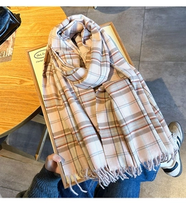 Close-up of pink and blue plaid scarf with fringe details and soft texture