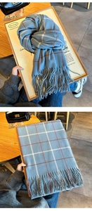Détail d'une écharpe à carreaux bleu et gris avec rayures bordeaux et franges