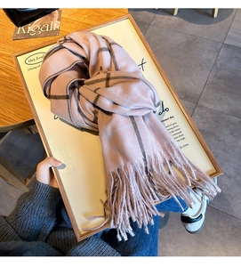 Gros plan sur l'écharpe à carreaux roses avec de longues franges et texture douce