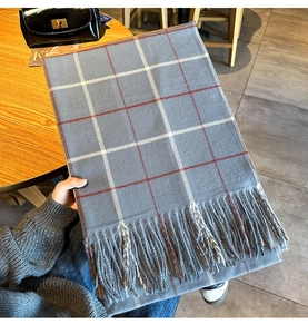 Gros plan sur une écharpe d'hiver épaisse avec un motif à carreaux gris et rouge
