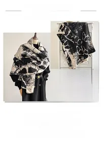 Detailed texture of thick beige pashmina shawl with ink butterfly patterns and fringe