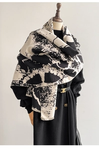 Detailed view of winter cashmere-feel scarf with artistic ink splash pattern and fringe