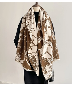 Detail of artistic ink butterfly pattern on thick brown and beige cashmere-feel shawl