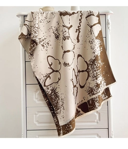 Detail of beige cashmere-like scarf with brown butterfly print and tassel edge trim