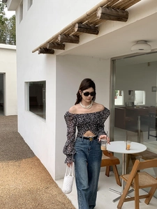 Tenue chic avec top fleuri à épaules dénudées, jean bleu et sac seau blanc au crochet