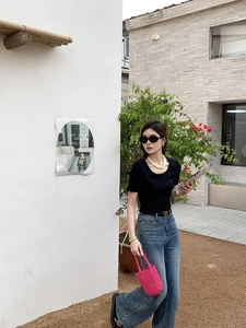 Photo en extérieur d'une femme portant un sac seau tressé rose vif avec une tenue d'été décontractée