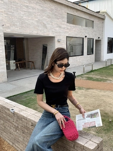 Détail d'un sac seau au crochet fuchsia fait main avec une tenue urbaine chic
