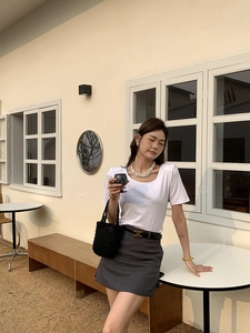 Tenue de style français avec un sac seau tissé à la main noir et mode d'été décontractée