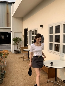 Détail d'un sac seau tissé noir fait main avec une tenue d'été et un collier de perles