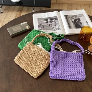Close-up of handmade crochet cotton bags in green, beige and purple with drawstring liners