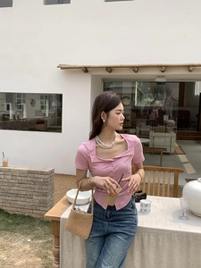 Detailed view of pink short-sleeve cardigan with square neck and button details