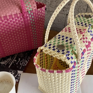 Détail de sacs cabas en PVC tissé avec motifs géométriques et textures de maille
