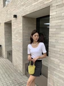 Sac seau en crochet jaune fait main stylisé avec une tenue de mode minimaliste