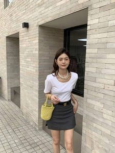 Photo de rue d'un sac seau jaune tissé à la main avec une tenue d'été décontractée