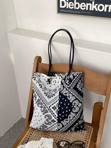 Detail view of paisley pattern canvas tote bag on vintage chair with natural lighting