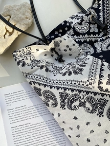 Detail of paisley canvas tote bag with drawstring closure and slim leather straps