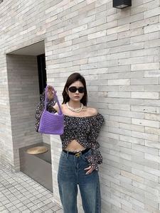 Detailed texture of purple handmade crochet cotton shoulder bag in outdoor setting