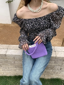 Street style view of a purple hand-woven cotton bag styled with a floral off-shoulder top