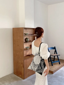 Detailed view of paisley canvas tote bag worn by model in light summer dress