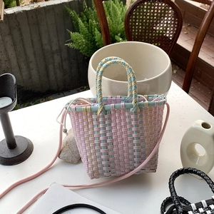 Macro detail of macaron-colored handwoven basket bag with pink strap for summer