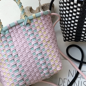 Detail of colorful and checkered handmade woven bags with handles and rope straps