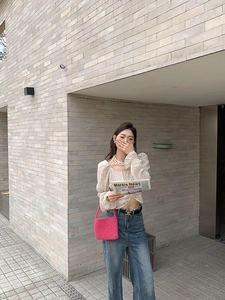 Detail of rose pink hand-woven cotton rope shoulder bag styled on model in street shot
