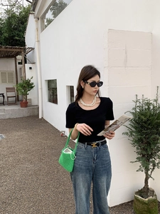Close-up of vibrant green hand-woven cotton rope handbag held by a model outdoors