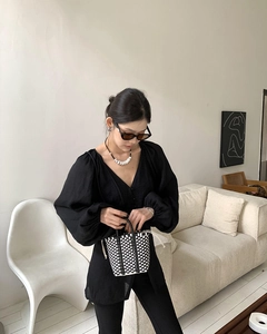 Detail of a chic black-and-white checkered woven mini handbag with stylish fashion outfit