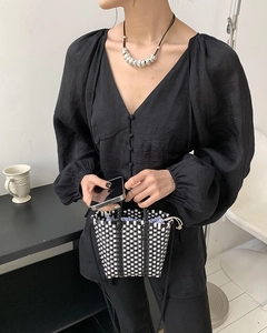 Detail of hand-woven mini tote bag with black and white texture for summer