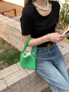 Detail of green handmade crochet woven bag with cotton cord texture and drawstring liner