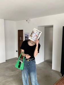 Fashion model showcasing a vibrant green handmade woven cotton rope shoulder bag with casual outfit