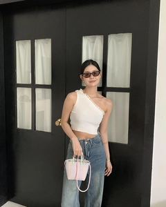 Detail of a white ribbed knit crop top with ruffled edges and high waist jeans