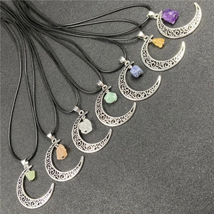 Macro detail of various crescent moon pendants with raw amethyst and quartz stones
