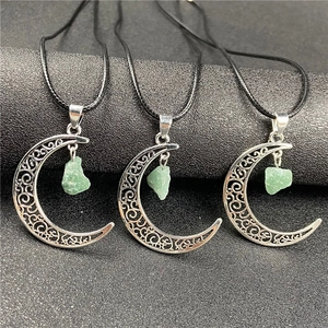 Detail of three hollow moon pendants with green raw stone on black cord necklaces