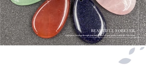 Macro shot of polished water drop crystal pendants in rose quartz and green aventurine