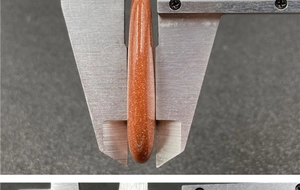 Macro shot showing the 10mm thickness of the polished goldstone teardrop pendant