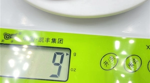 Macro shot of digital scale LCD display showing 9g weight with mode buttons
