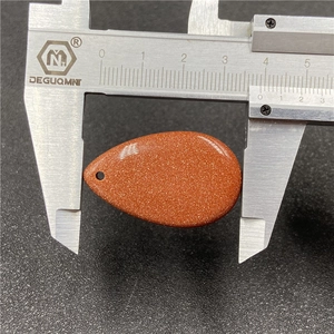 Brown goldstone water drop pendant measured with caliper showing 35mm width size